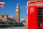 Iconic red telephone booth with Big Ben and Houses of Parliament in London, UK.