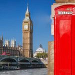 Iconic red telephone booth with Big Ben and Houses of Parliament in London, UK.