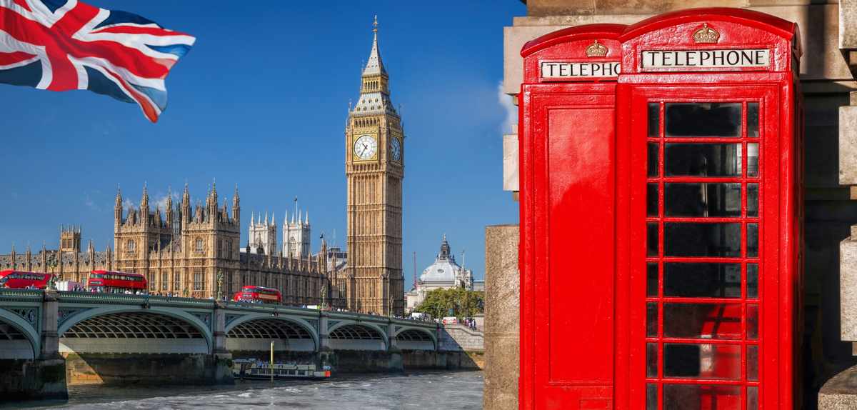 Iconic red telephone booth with Big Ben and Houses of Parliament in London, UK.
