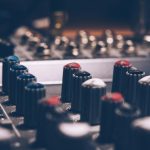 "Close-up of audio mixer control knobs in a recording studio"