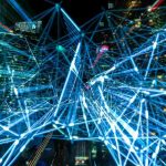 "Abstract visualization of digital network connections with glowing blue lines over a cityscape"