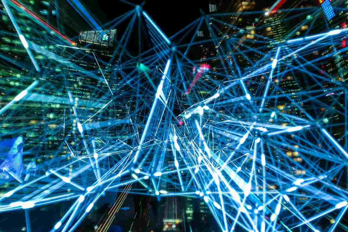 "Abstract visualization of digital network connections with glowing blue lines over a cityscape"