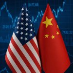 U.S. and China national flags side by side with a financial chart in the background symbolizing trade tensions.