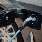 Close-up view of an electric car being charged, symbolizing the growth of the global EV market and clean transportation trends.