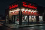 Tim Hortons coffee shop illuminated at night with glowing red signage.