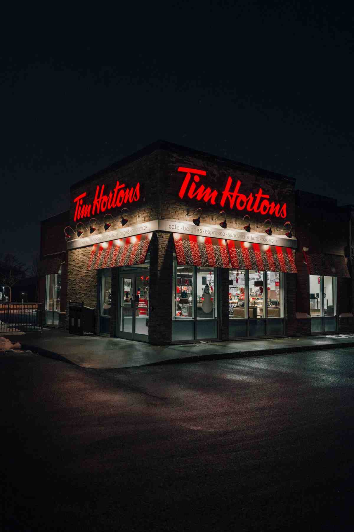 Tim Hortons coffee shop illuminated at night with glowing red signage.