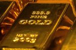Stacks of gleaming gold bars symbolizing record-high gold prices and investor confidence in safe-haven assets.