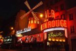 Moulin Rouge cabaret illuminated at night in Paris, France.