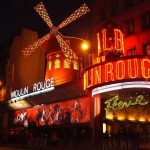 Moulin Rouge cabaret illuminated at night in Paris, France.