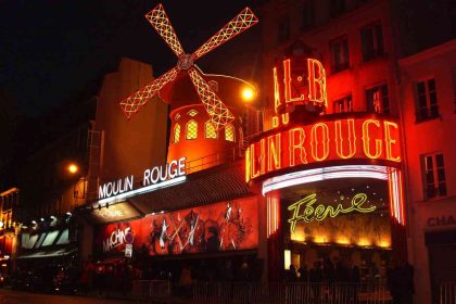 Moulin Rouge cabaret illuminated at night in Paris, France.