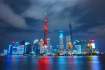 Shanghai skyline at night with Oriental Pearl Tower and illuminated skyscrapers.