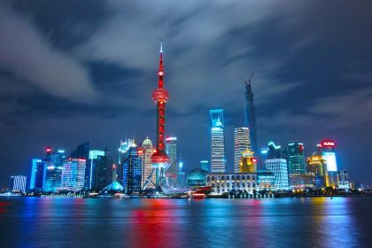 Shanghai skyline at night with Oriental Pearl Tower and illuminated skyscrapers.