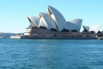 Sydney Opera House viewed from the harbor with clear blue skies.