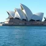 Sydney Opera House viewed from the harbor with clear blue skies.