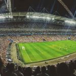 Panoramic view of a packed football stadium during a night match.