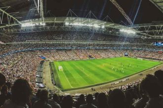 Panoramic view of a packed football stadium during a night match.