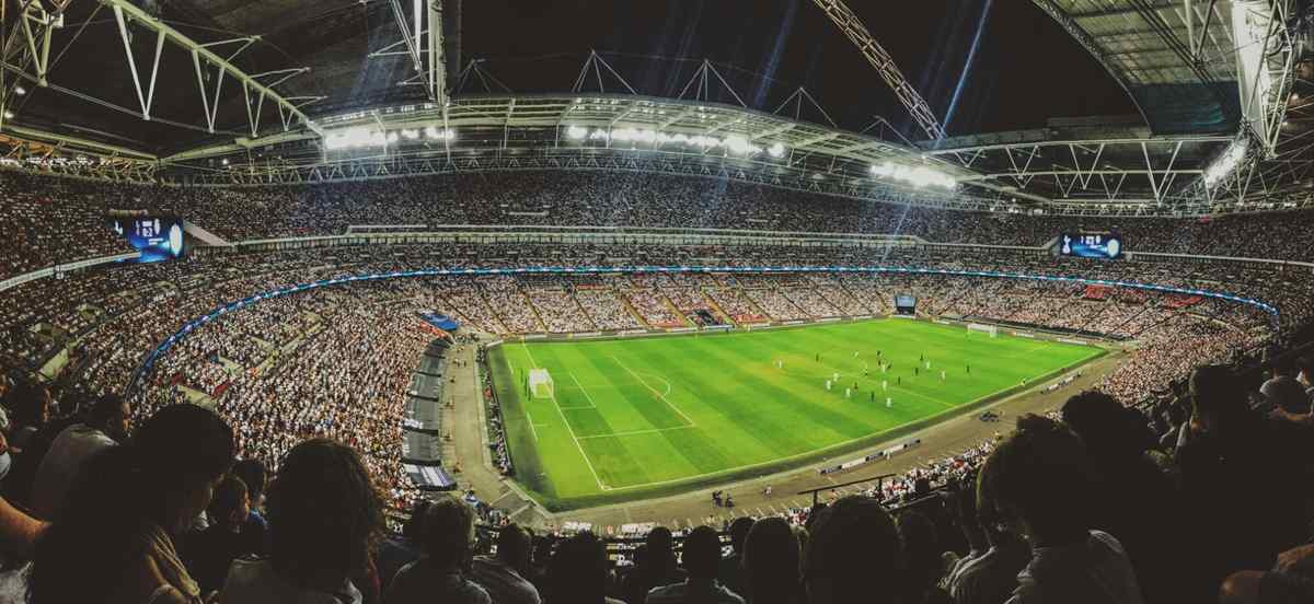 Panoramic view of a packed football stadium during a night match.