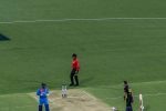 Indian cricket player celebrating a victory on the pitch during an international match under stadium lights.